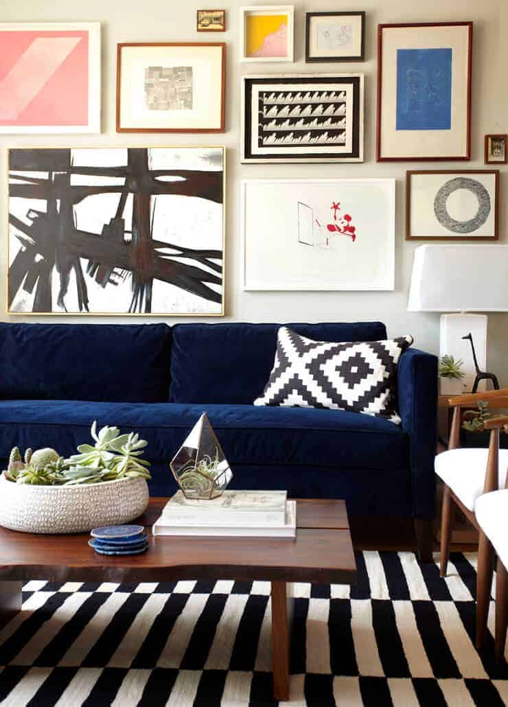 gallery wall above navy sofa